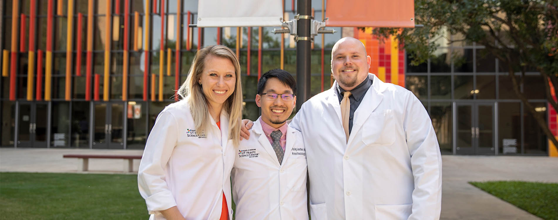 Three Anesthesiology residents in front of the ALT C Building