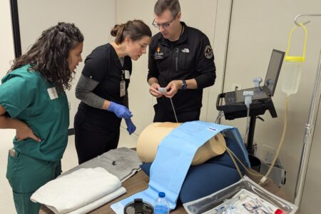 Doctors training using ultrasound machine and torso manakin.