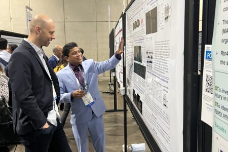 Gentleman presenting his work during the poster session event