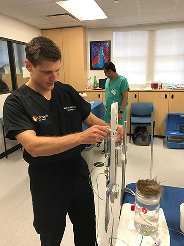 A participant standing in a clinical room during our "Fundamentals of Neurosurgery" boot camp.