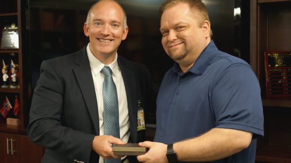 Dr. John Floyd presents Carl Middleton with an award commemorating his fifth year at the Department of Neurosurgery.