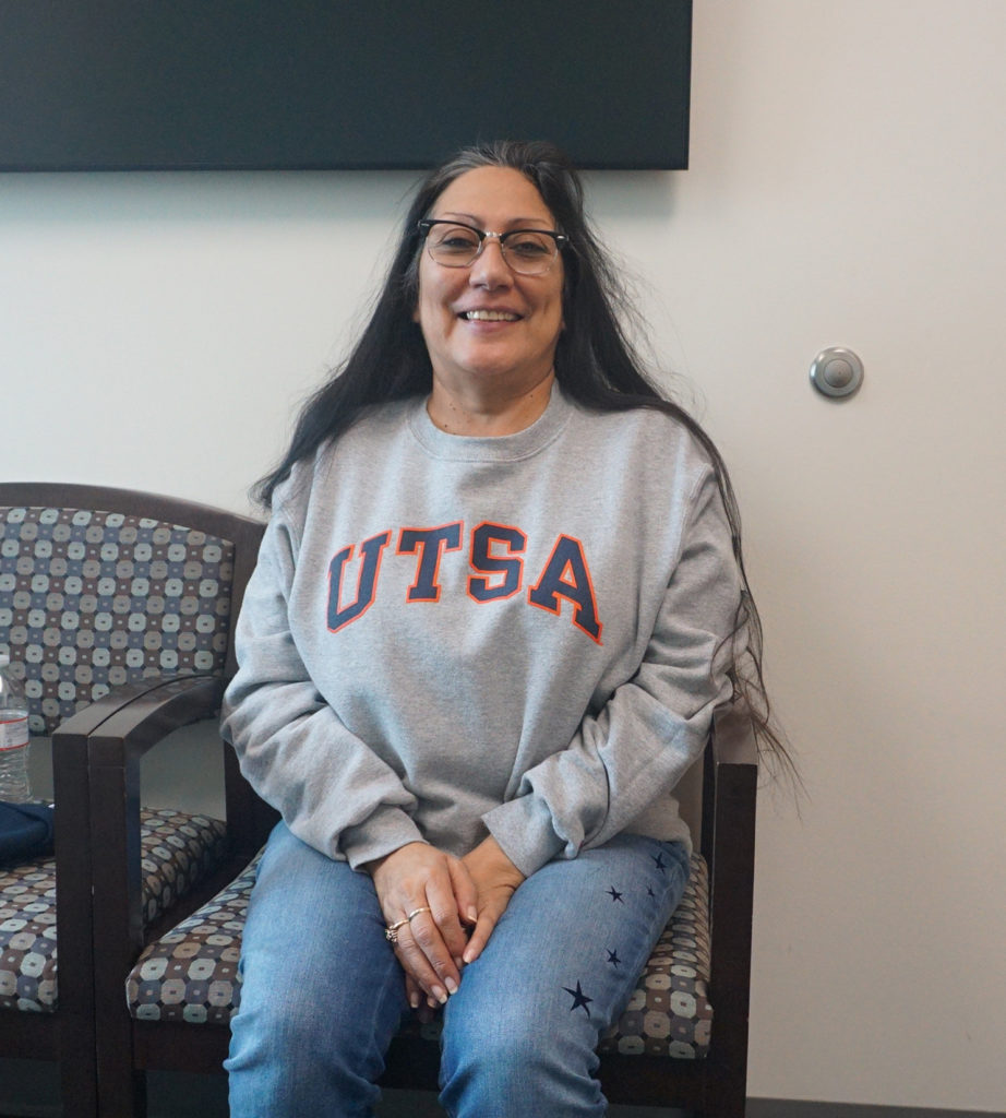 Patient Sandra Holquin sitting in a chair and smiling.