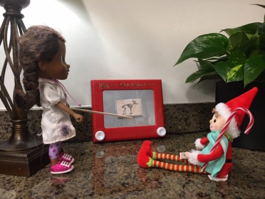 An elf sits in front of a diagram depicting the skeleton of a reindeer.