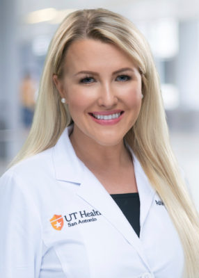 Ashleigh Johns poses for a photo in a white labcoat