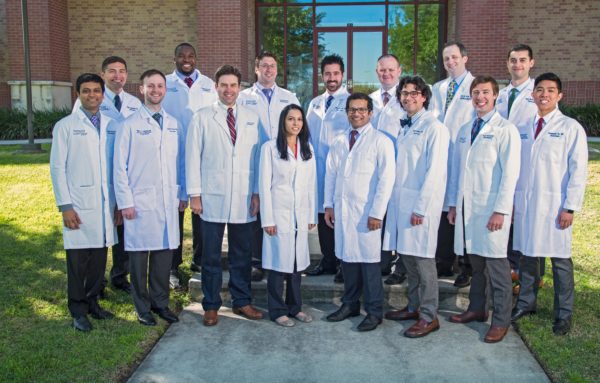 A residents from the Department of Neurosurgery standing outside and smiling.