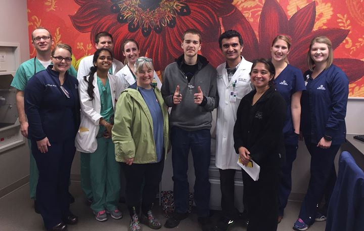 Michael Shugart standing with thumbs up while he is surrounded by the Neurocritical Care Team.