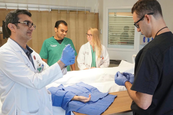 Dr. Seifi demonstrates something in clinic with his hands.