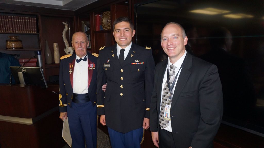 Dr. Shane Hawksworth standing and smiling in military dress while he is flanked by Dr. James Henry and Dr. John Floyd.