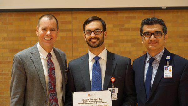 Dr. Ali Seifi and Dr. Robert Hromas flank William Chase Johnson as he holds his UT Health San Antonio Dean's Research award for his research project.