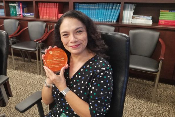 Former Business Administrator Rachal Cardenas holding her farewell gift and smiling.