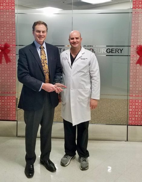 Drs. Van Horne and Papanastasiou standing in front of the Department of Neurosurgery doors.