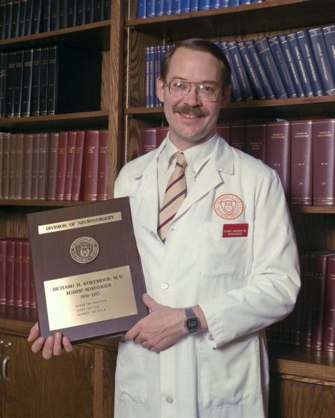 Dr. Richard Kokemoor posing with graduation plaque.