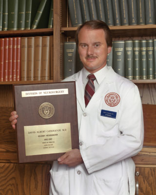 Dr. David Cavanaugh posing with graduation plaque.