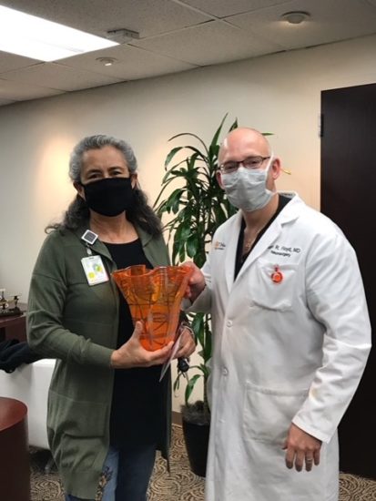 Esther Nanez receiving a gift from Dr. Floyd