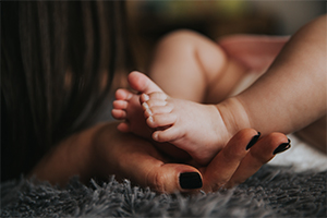 Female hands and infant feet