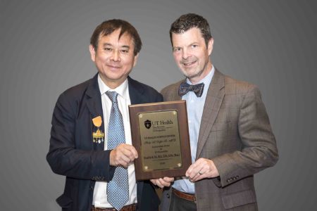 Robert H Quinn, MD presents plaque to Freddie H Fu, MD at the Twenty-Second Annual Phillip A Deffer, Sr, MD Lecture on April 23, 2018.