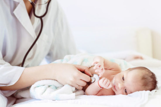 Female doctor examines infant with stethoscope