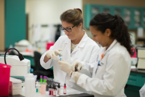 Two female research colleagues working together in laboratory setting