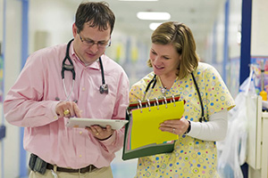 Image of a doctor and a nurse reviewing information on a chart