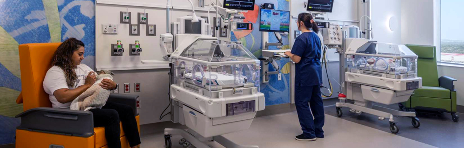 Image of Mother nursing a child with Neonatology technician in UT Health San Antonio NICU